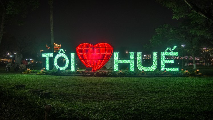 The vibrant "TÔI ❤️ HUẾ" sign illuminating the night in Vietnam's ancient capital